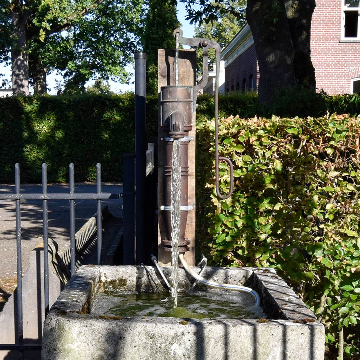 Wastrog-van-zandsteen-met-waterpomp