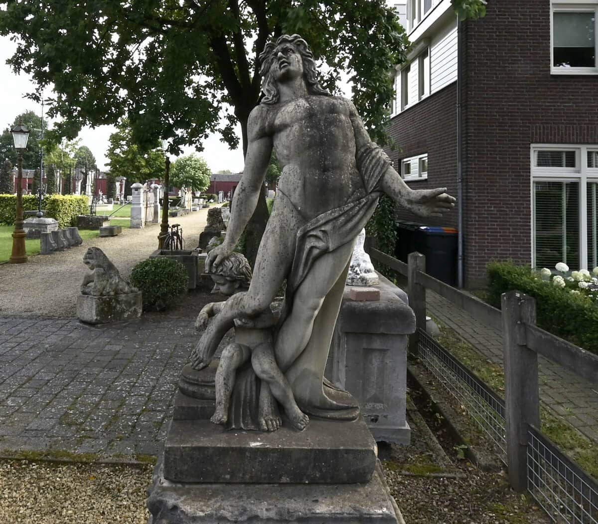 zandstenen-beeld-man-met-kind-op-sokkel