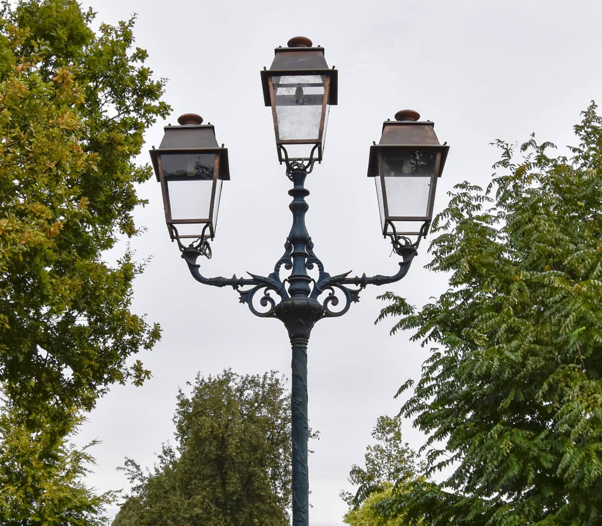 Exlusieve-driemast-lantaarnpaal-met-koperen-kappen